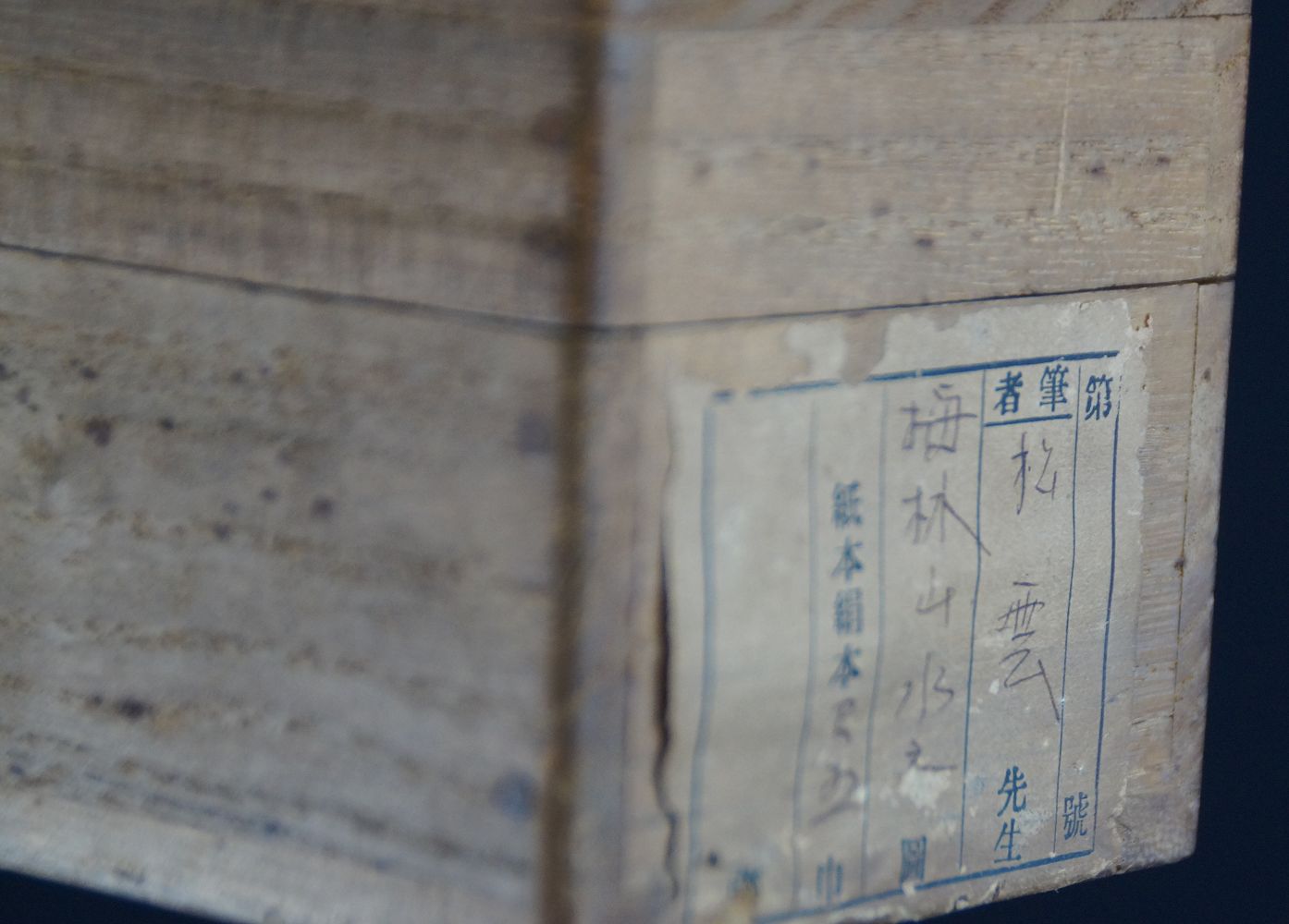 Nahaufnahme des Boxdeckels mit Tuschebeschriftung und Titeletikett der Aufbewahrungsbox des Kakemono Pflaumenblueten im Mondnebel
