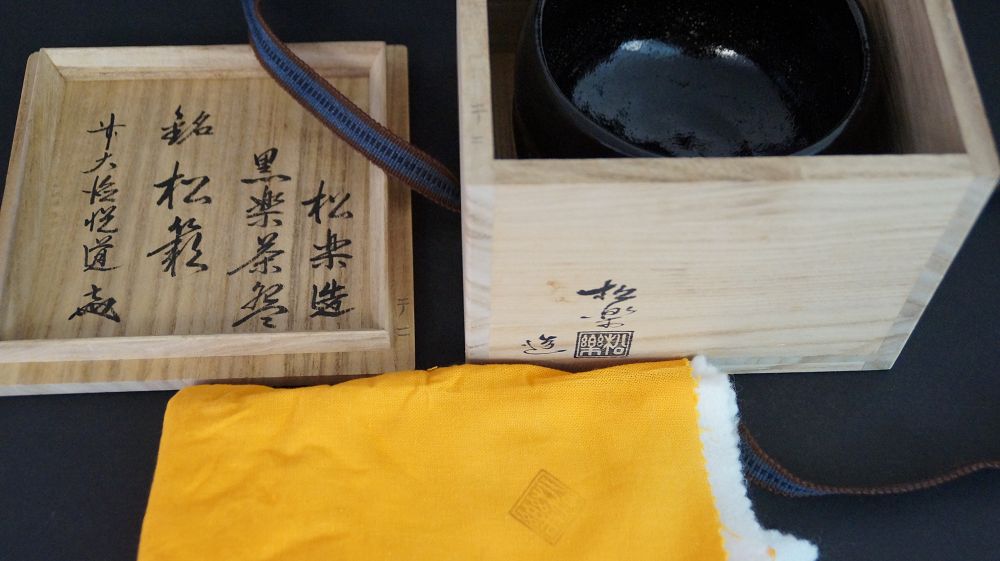 Chawan en céramique Raku dans la boîte de rangement ouverte à côté du couvercle de la boîte inscrit