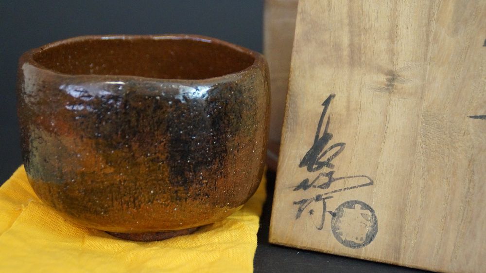 Chawan de cerámica de Ohi junto a la caja de conservación firmada con sello redondo del artista
