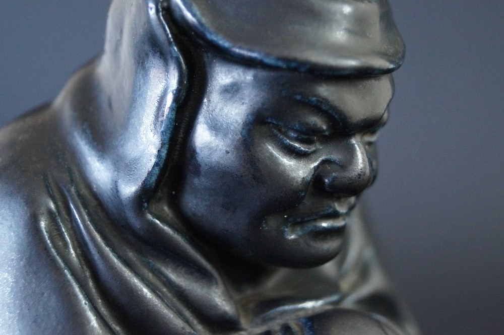 Figura de Bodhidharma Daruma de porcelana negra primer plano del rostro 1