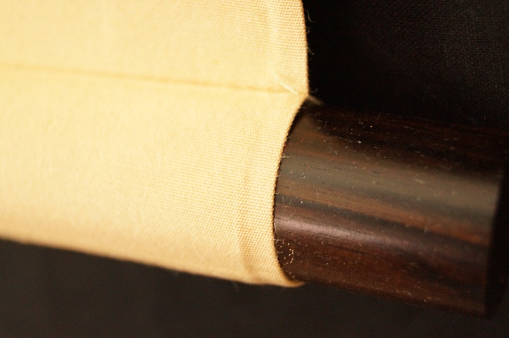 Textile edge and wooden rod scroll end scroll detail