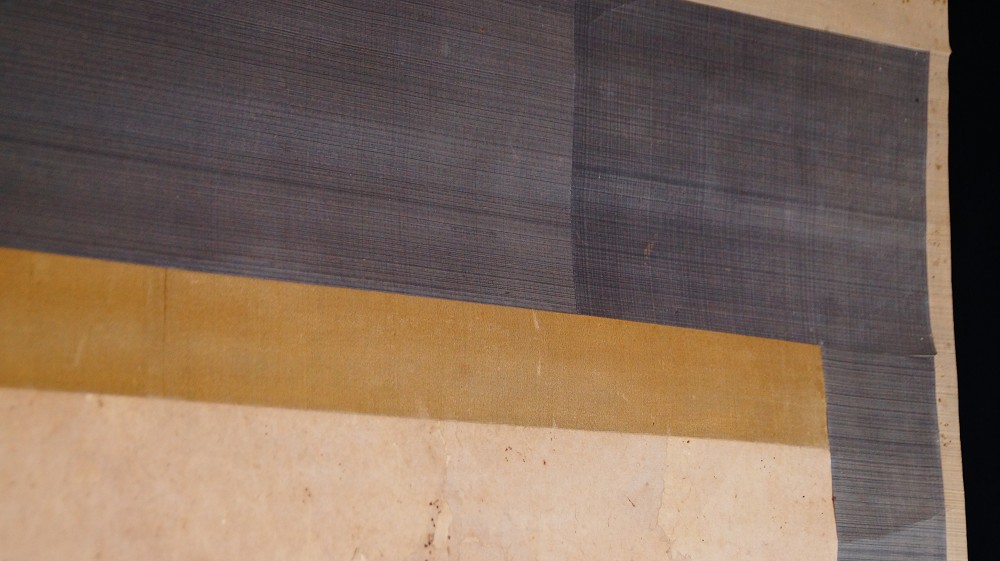 Detail der grau-goldenen Seidenmontierung des Kakemono
