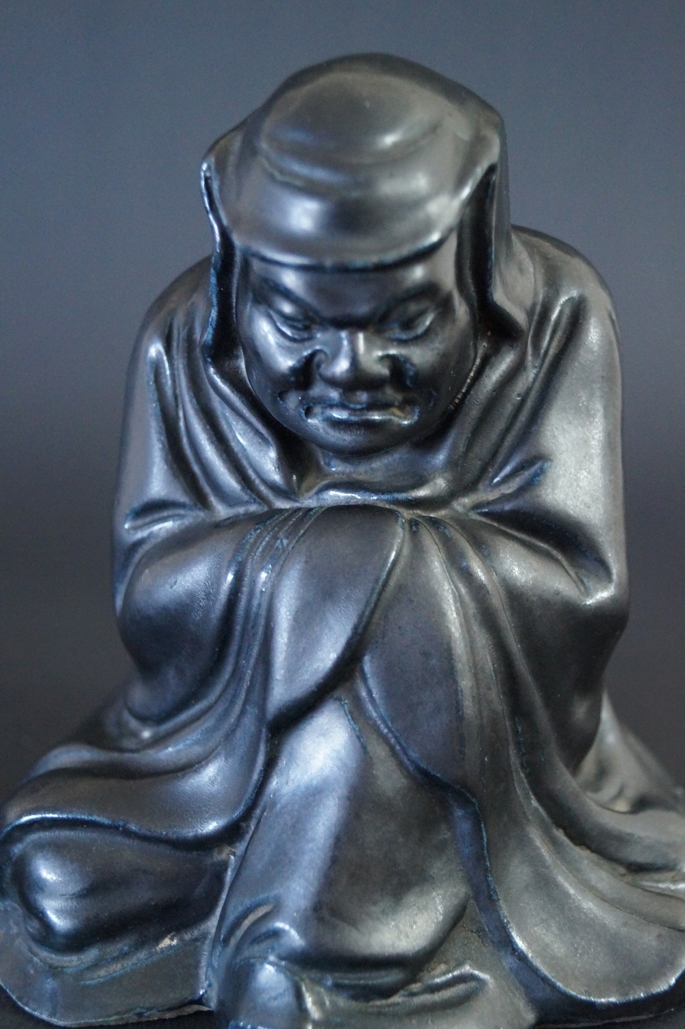 Bodhidharma Daruma figura de porcelana negra vista frontal primer plano