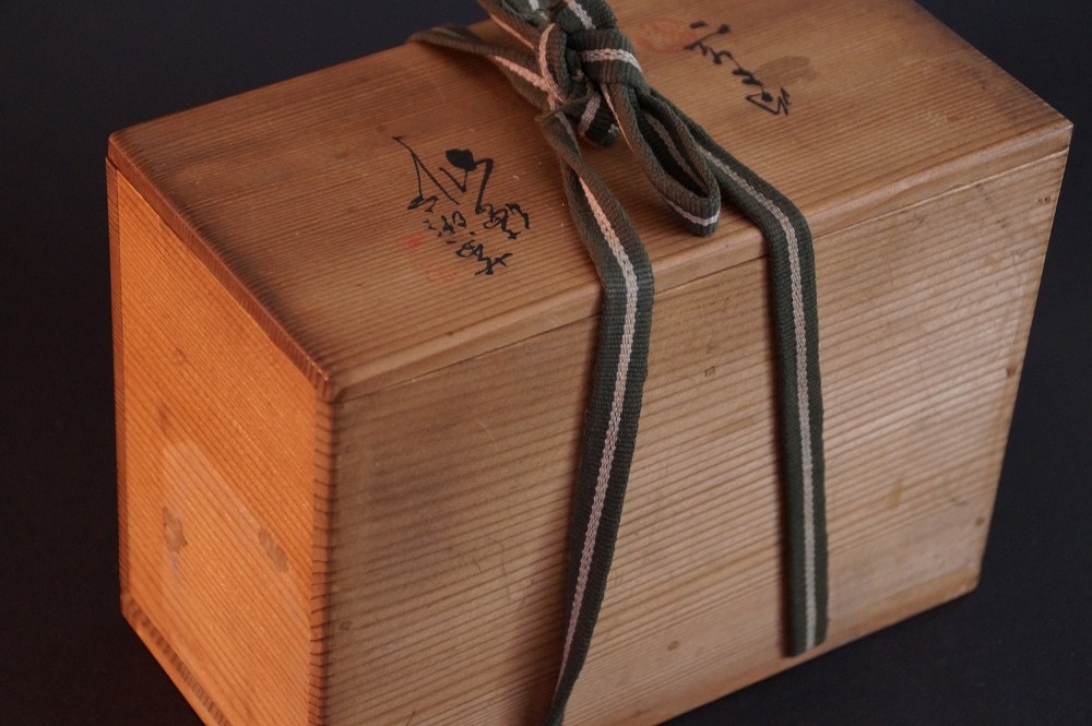 Mit gruen-weisser Kordel verschnuerte Aufbewahrungsbox des Sets