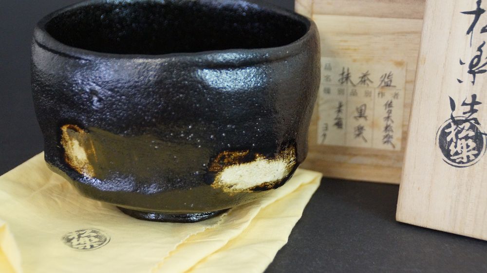 Cuenco de té de cerámica Raku junto a la caja de conservación firmada con etiqueta inscrita