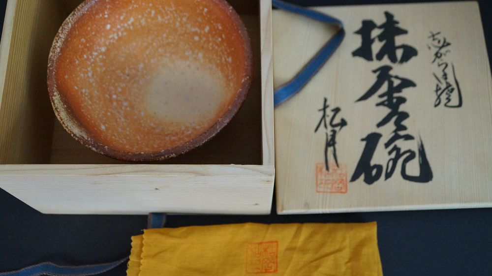 Chawan de cerámica de Shigaraki en la caja de conservación abierta junto a la tapa firmada de la caja