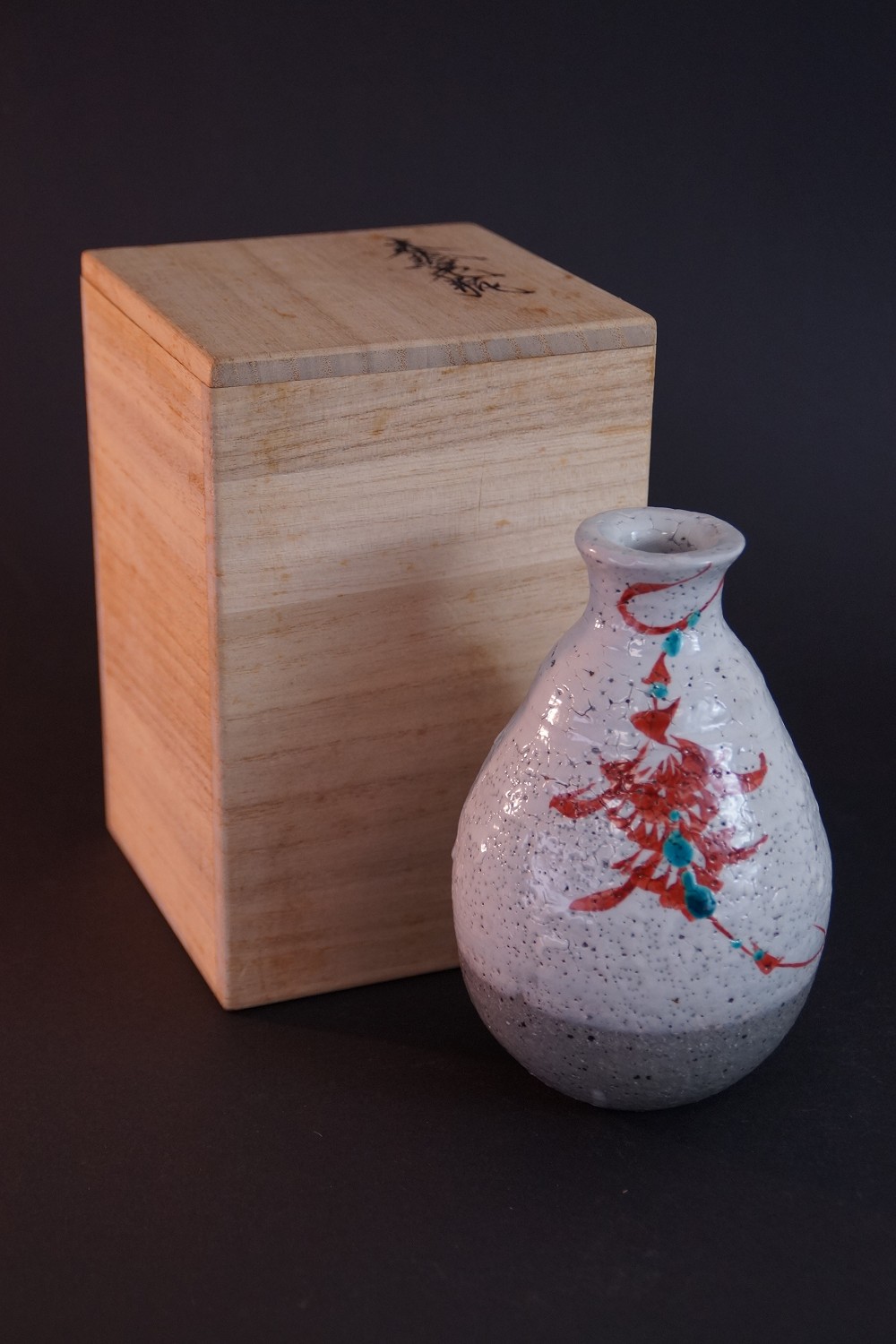 Die Sake Flasche vor der signierten Aufbewahrungsbox