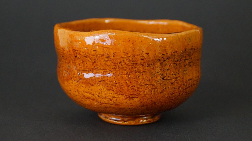 Weitere Ansicht der Chawan Teeschale aus Ohi-Keramik mit gleichmaessiger orangefarbener Glasur