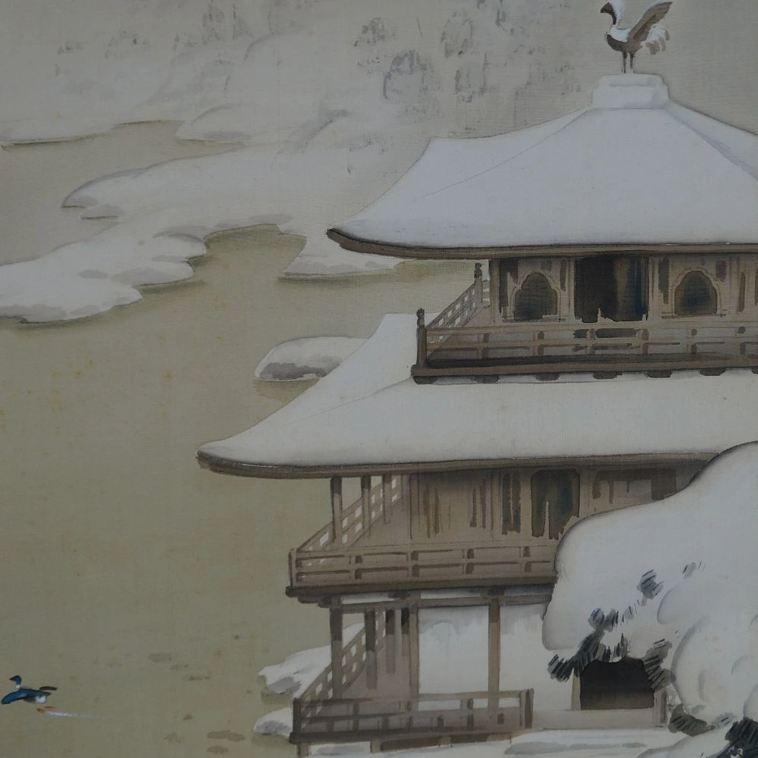 Nahaufnahme des schneebedeckten Klostergebaeudes mit Voegelfigur auf dem Dachfirst im Kakemono Verschneites Kloster am stillen See