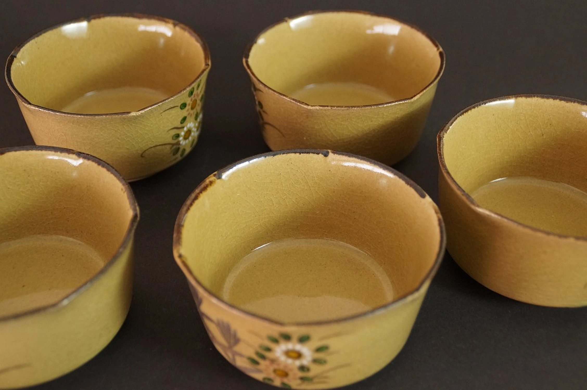 Further close-up of the five bowls with visible dark brown glazed interior