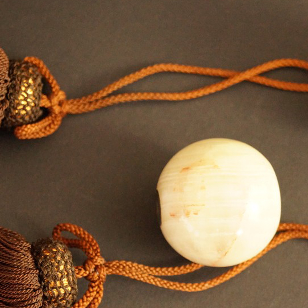 Zwei helle Natursteinkugeln mit braunen Seidenquasten Set Nahaufnahme Vorschau