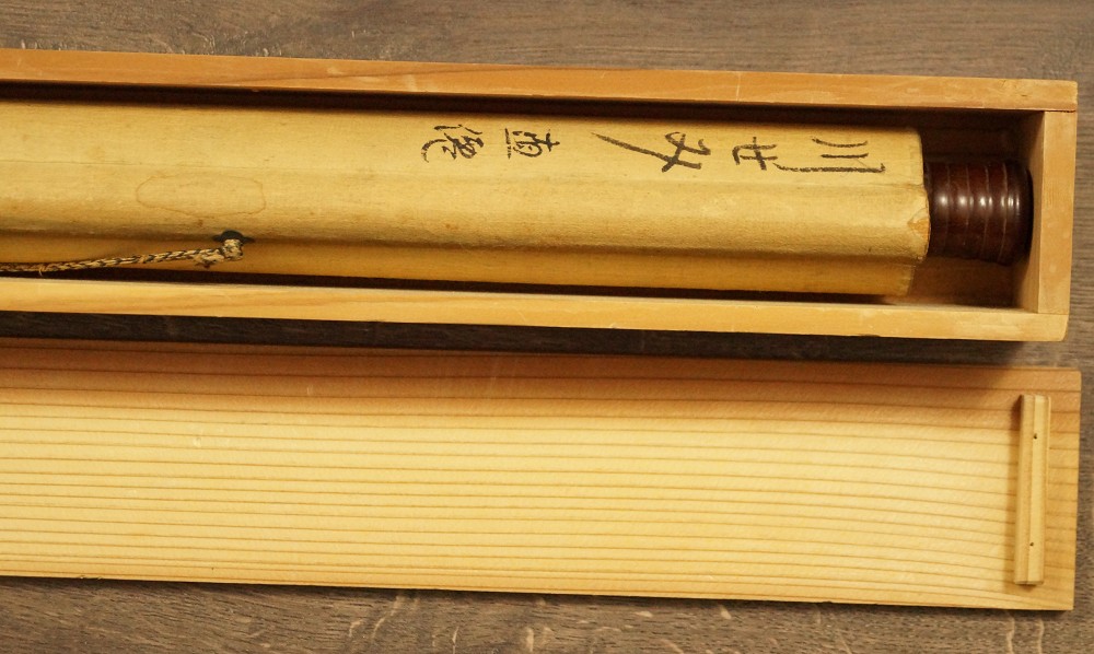 Rollo colgante enrollado con etiqueta de papel escrita en caja de madera kakemono enrollado