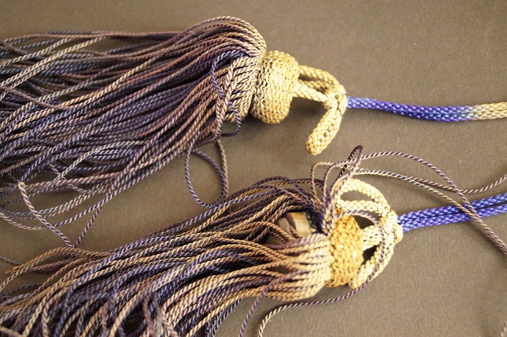 Nappe di seta viola e dorata con cordoncino blu primo piano nappa