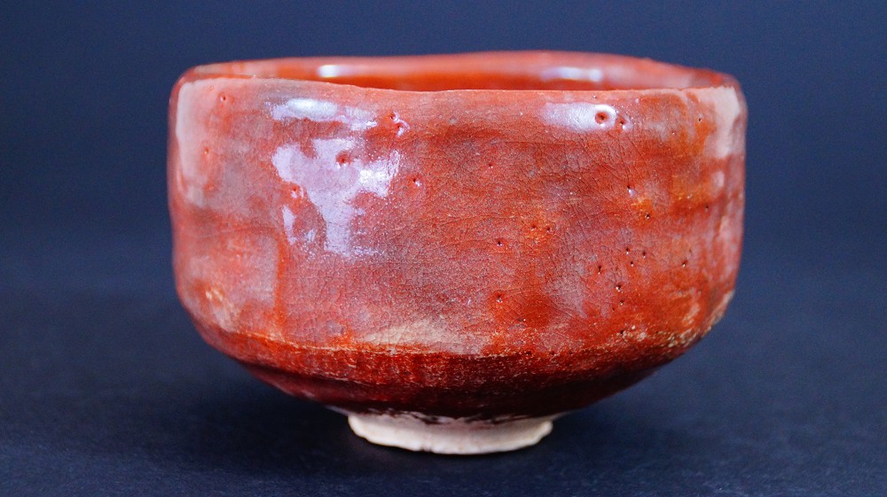Otra vista lateral del chawan de cerámica Raku de Sairi Hotoku con esmalte rojo intenso