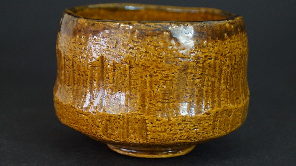 Weitere Ansicht der Chawan aus Raku-Keramik von der Seite mit honigfarbener Glasur