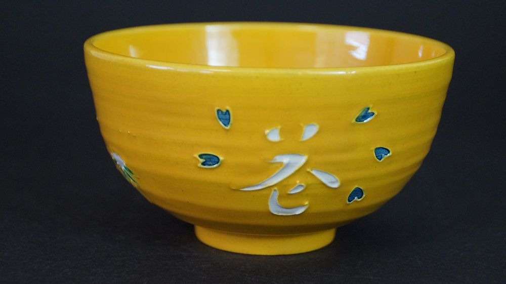 Weitere Ansicht der Chawan aus Kyoto-Keramik mit weiss aufgetragenem Schriftzeichen und blauen Akzenten