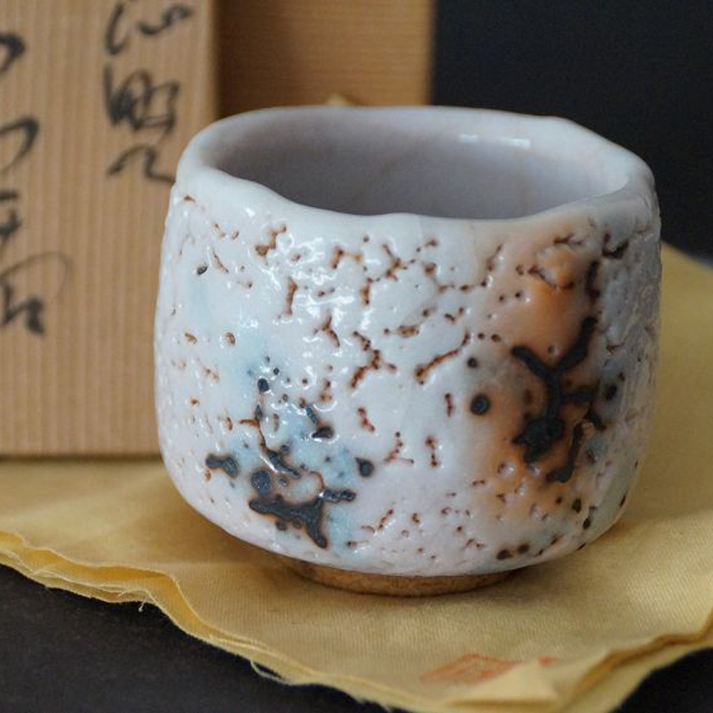Guinomi aus Shino-Keramik von Takeshi Kato mit craquelierter weisser Glasur vor der beschrifteten Aufbewahrungsbox