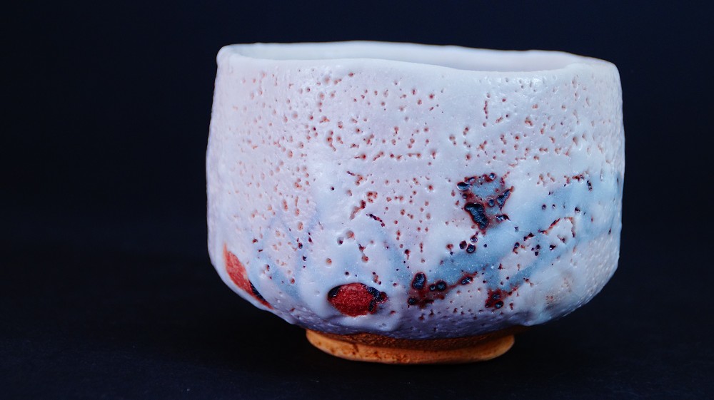 Weitere Seitenansicht der Chawan aus Shino-Keramik von Jyuzo Sato mit deutlich sichtbaren roten Feuerspuren