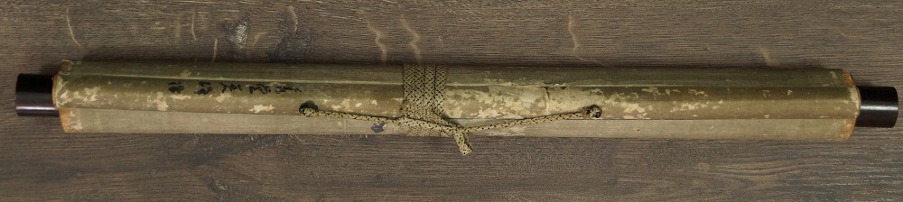 Zusammengerolltes und mit Kordel verschnuertes Kakemono mit Jikusaki aus Holz