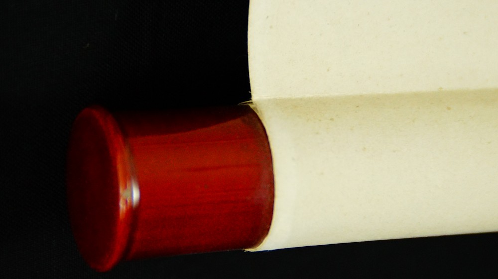 Nahaufnahme des rot lackierten Rollenendes des Kakemono