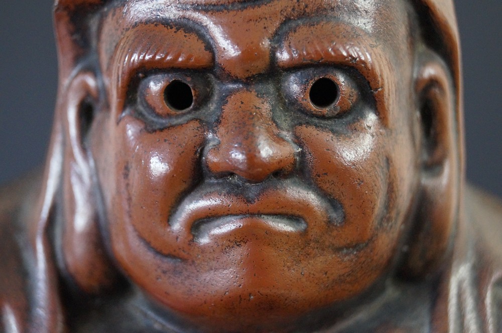 Daruma Figur aus Bizen Keramik Gesicht Nahaufnahme Detail