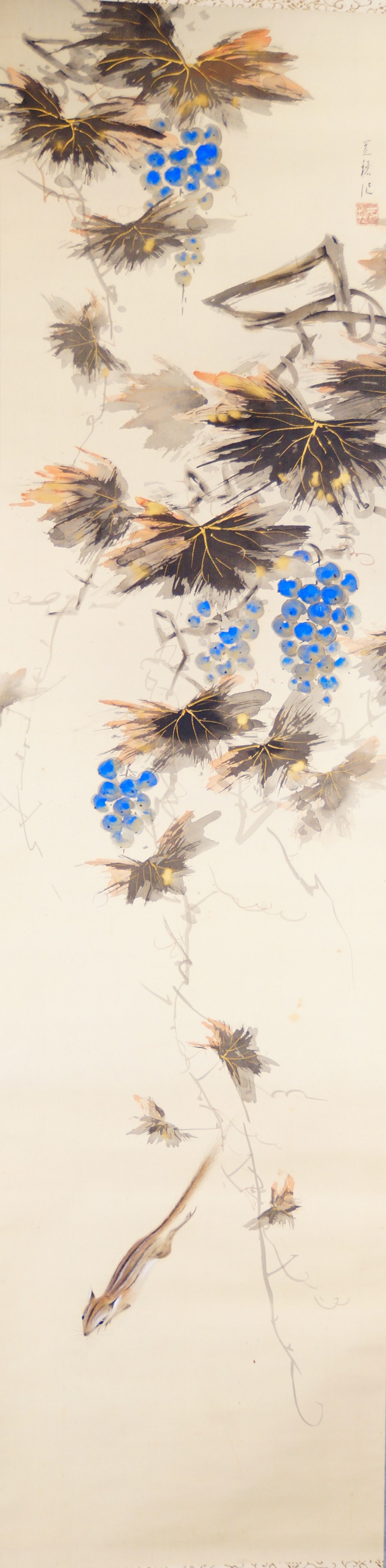 Weinranken mit blauen Trauben, herbstlich gefaerbten Blaettern und einem Streifenhoernchen im Kakemono von Sano Mitsuho mit Kuenstlersignatur und rotem Siegel