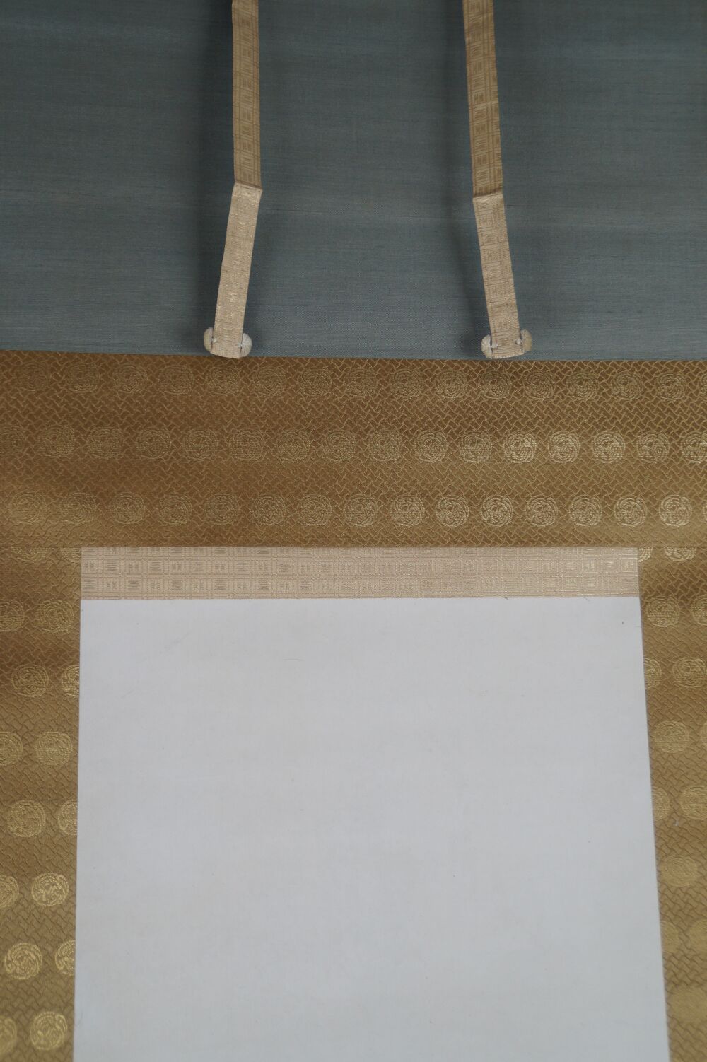 Detailansicht der Seidenmontierung mit Goldbrokat und Aufhaengebaendern des Kakemono