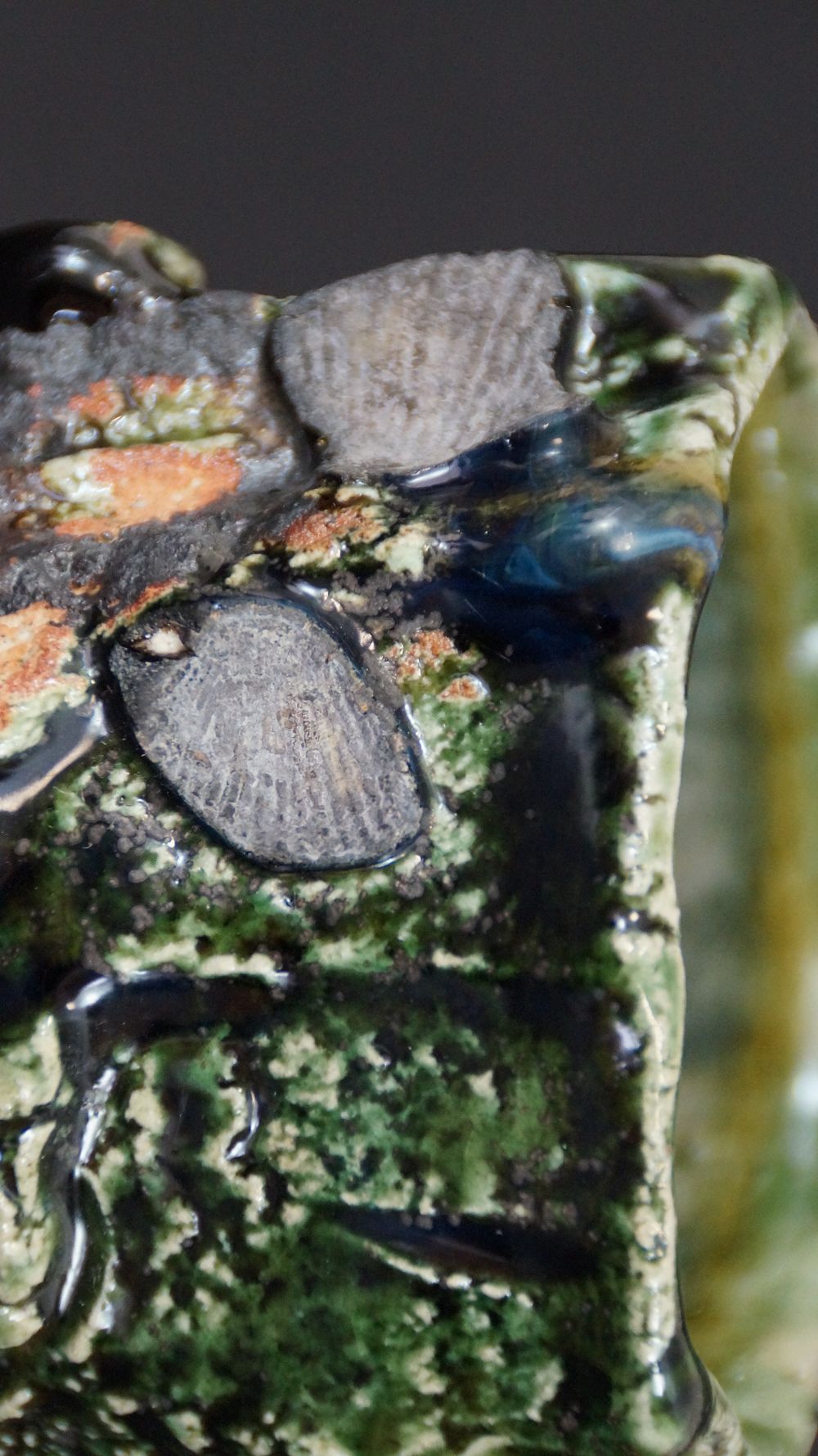 Nahaufnahme des Randes mit muschelartigen Steineinschluessen der Yunomi Tee-Schale aus Oribe-Keramik