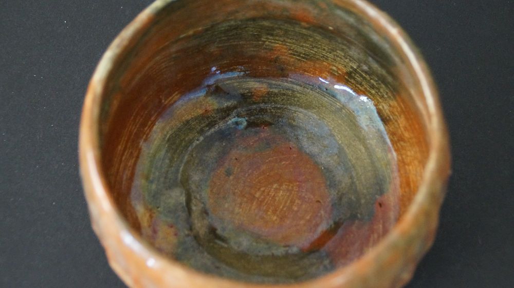 Nahaufnahme der spiralfoermig aufgetragenen Innenglasur der Chawan Teeschale aus Raku-Keramik