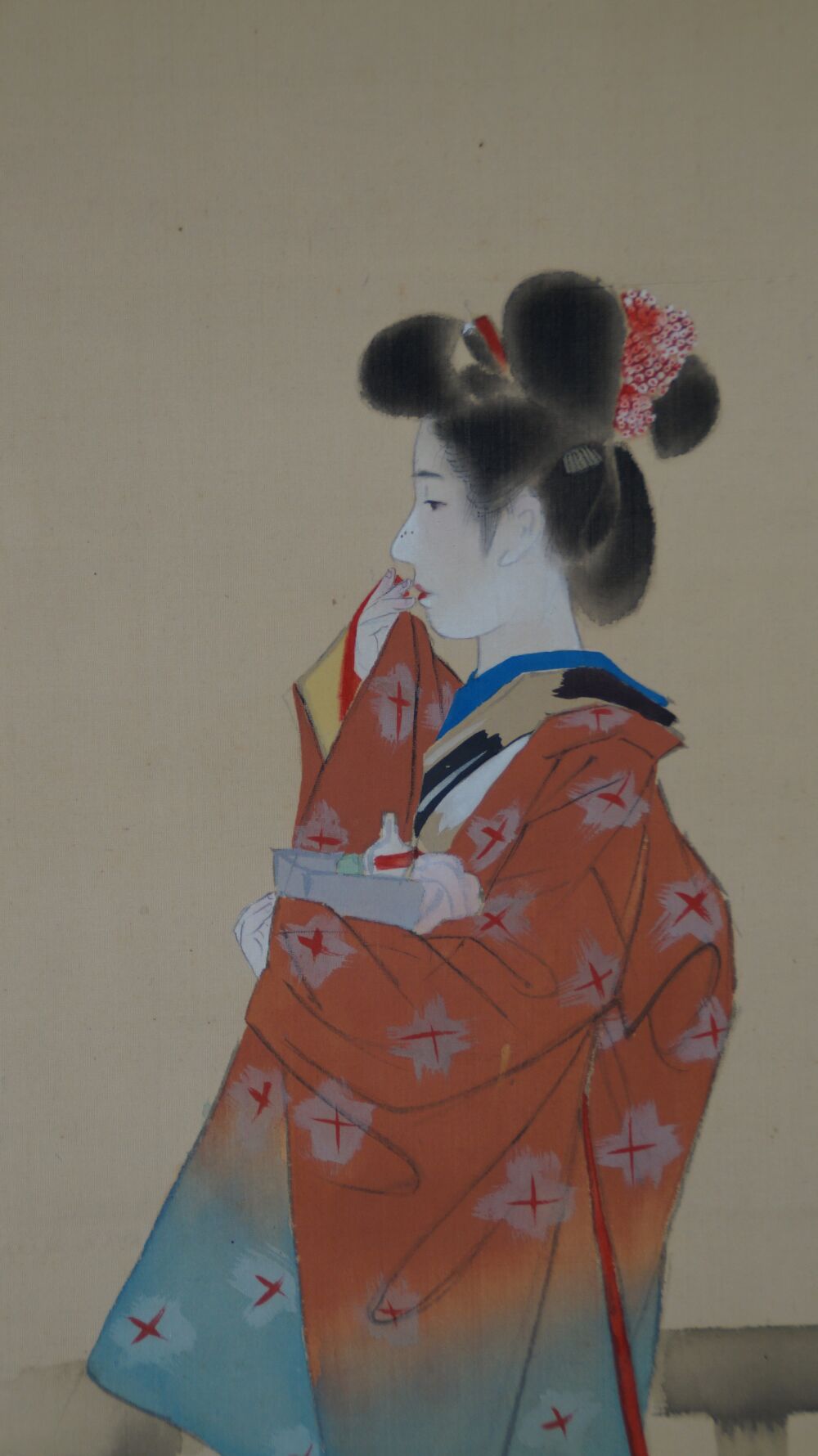 Weitere Nahaufnahme der jungen Frau beim Auftragen von Lippenrot im Kakemono Schoenheit im Kimono