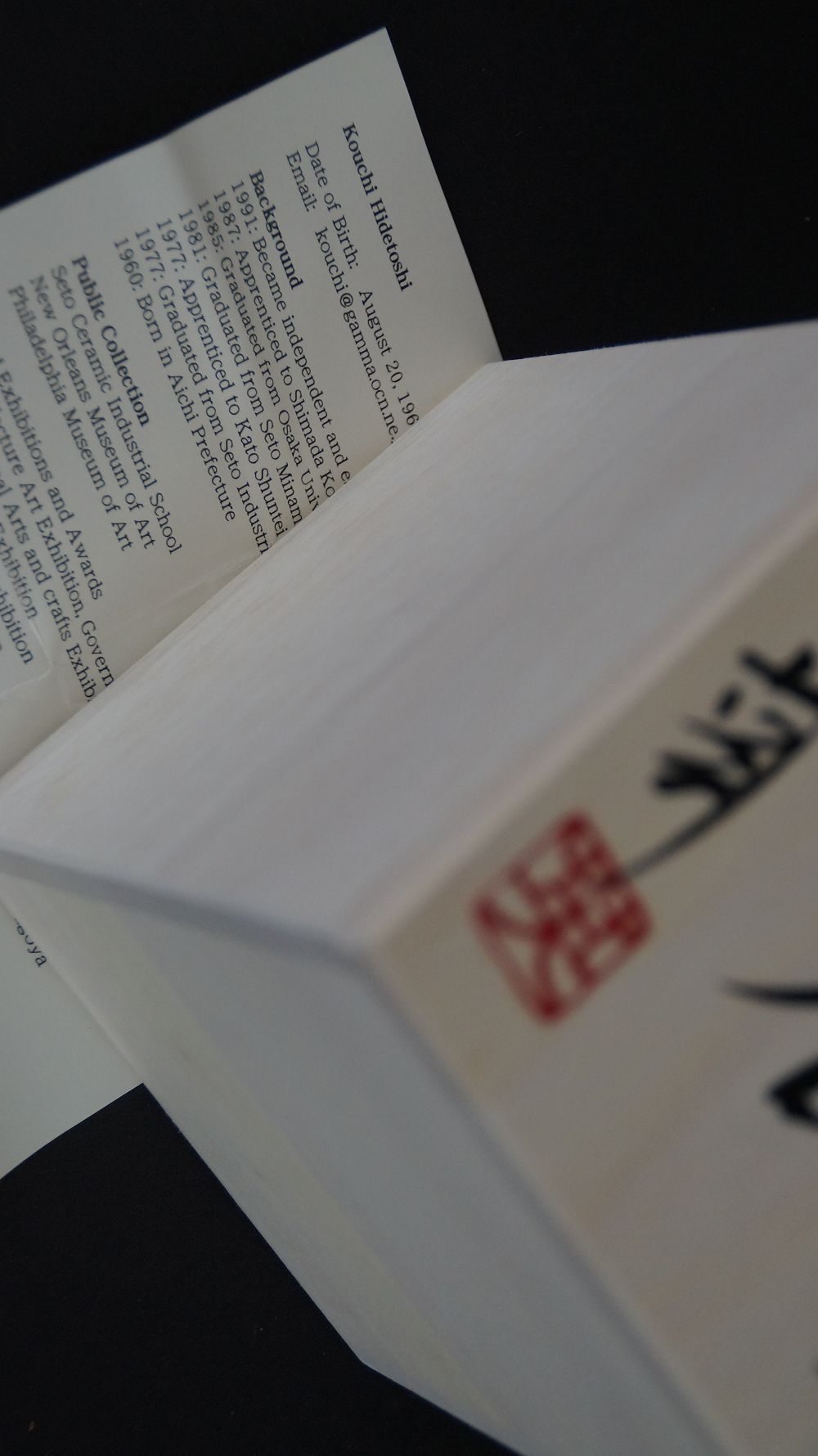 Signierter Kastendeckel mit rotem Kuenstlersiegel neben der Kuenstlerbiografie der Yunomi Tee-Schale aus Oribe-Keramik