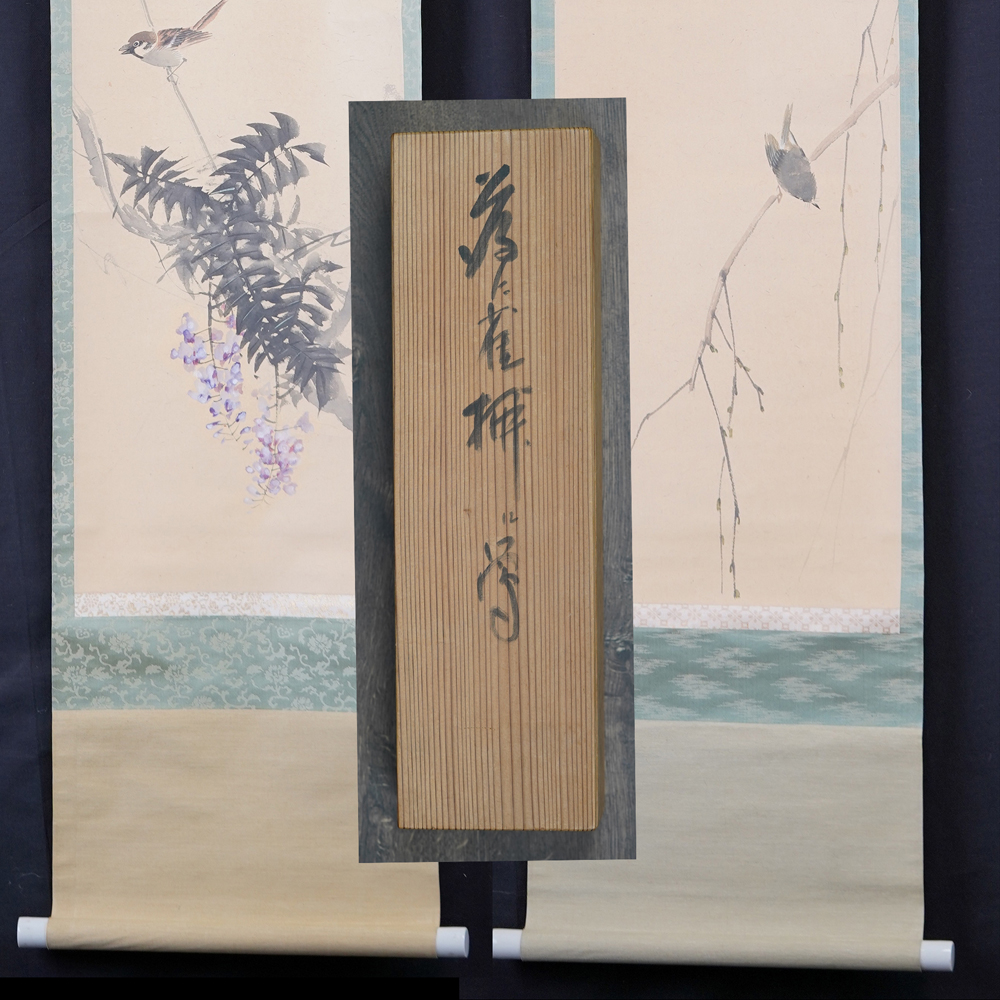 Both hanging scrolls of the set Sparrow on Wisteria and Willow Branch hanging side by side with the lid of the storage box