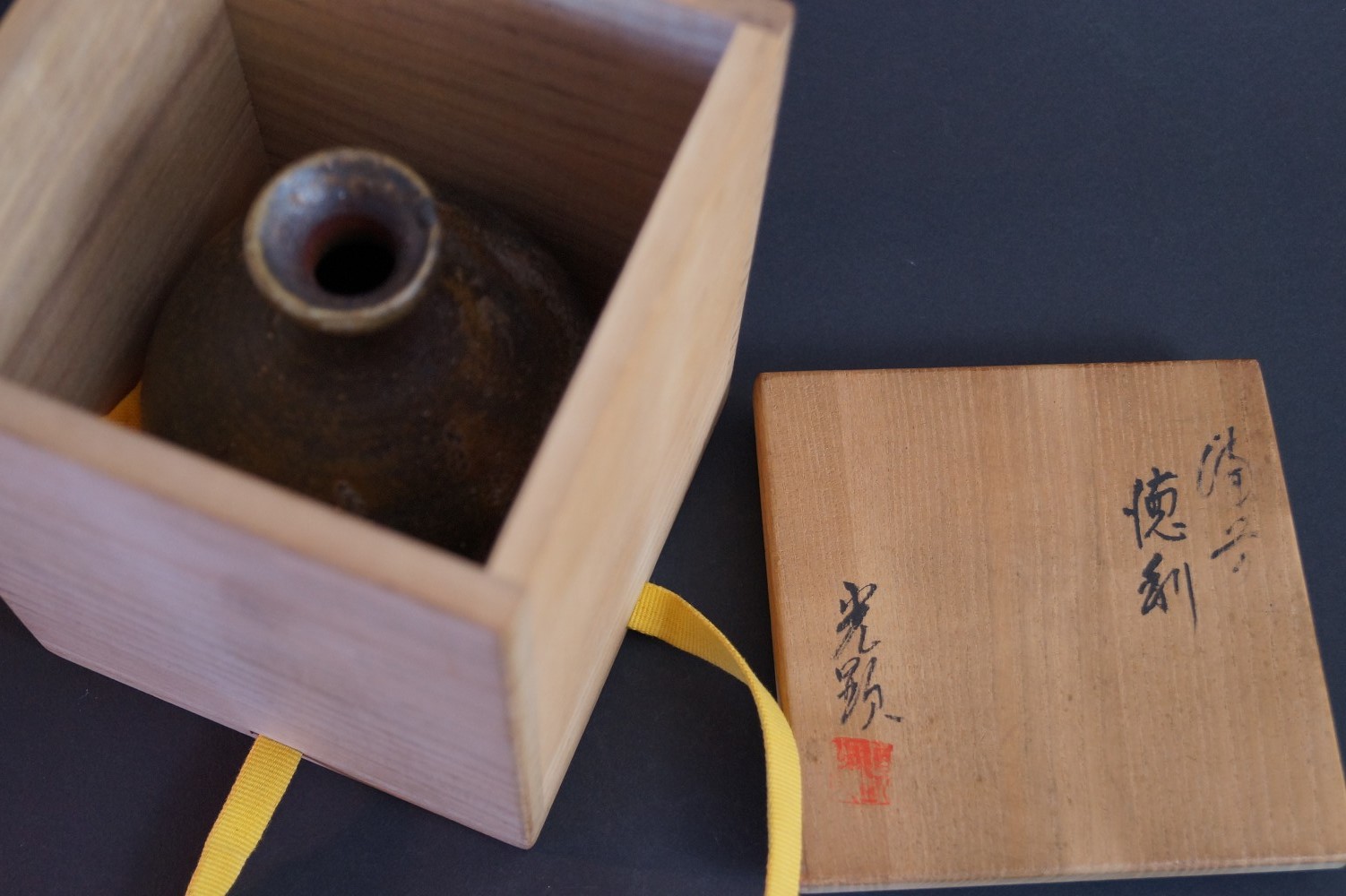 La botella de sake de pie en la caja de almacenamiento abierta