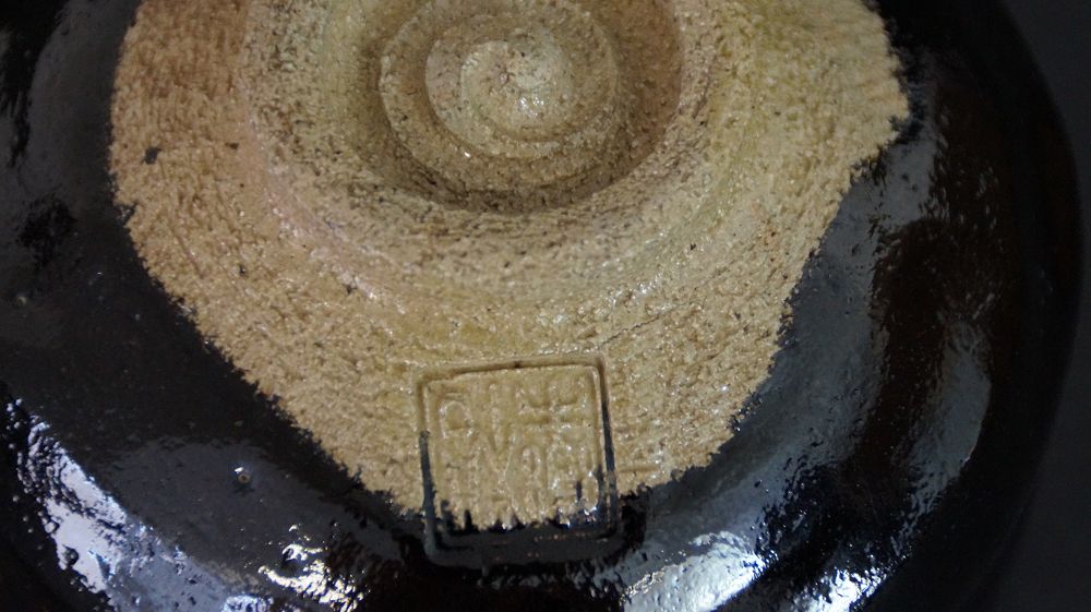 Vue détaillée du pied avec sceau de l'artiste imprimé du chawan en céramique Raku
