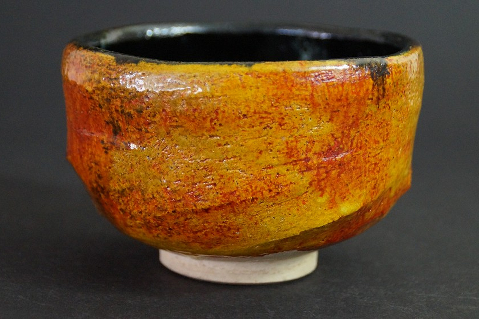 Chawan aus Tobe-Keramik mit bernsteinfarben-rötlicher Glasur und schwarzem Innenrand