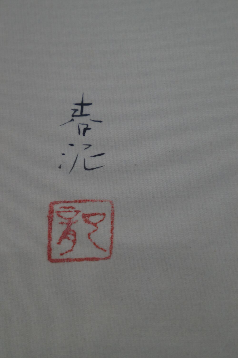Vista de detalle de la firma del artista y del sello rojo en el kakemono uguisu sobre ciruelo en flor