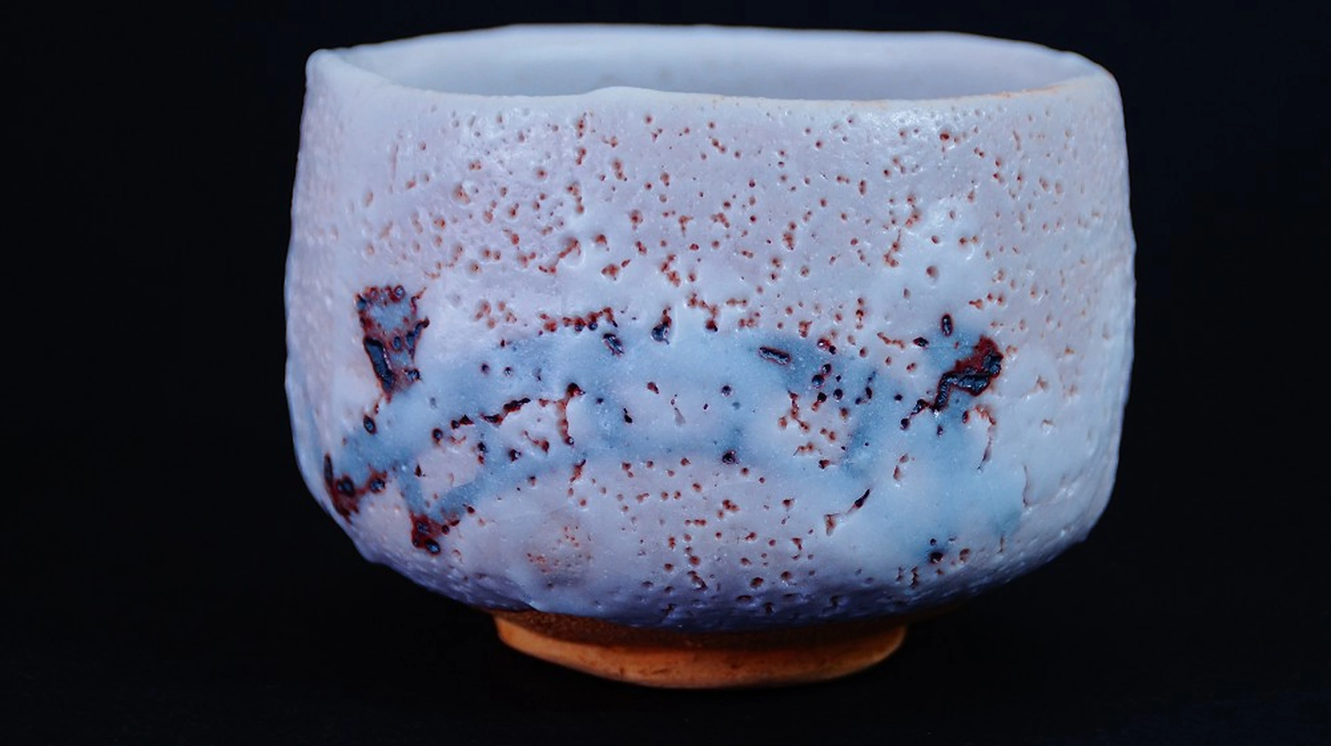 Chawan in ceramica Shino di Jūbei-gama in vista frontale con smalto bianco-lavanda e banda di tracce di fuoco rossa