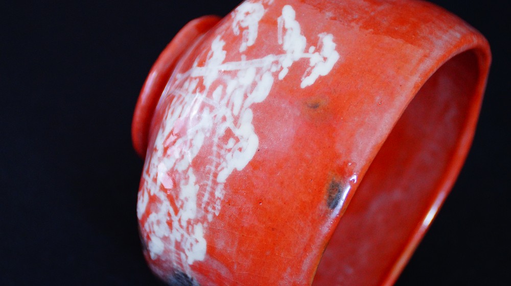 Weitere Nahaufnahme des weiss gemalten Motivs am Lippenrand der Chawan aus Raku-Keramik von Waraku Kawasaki