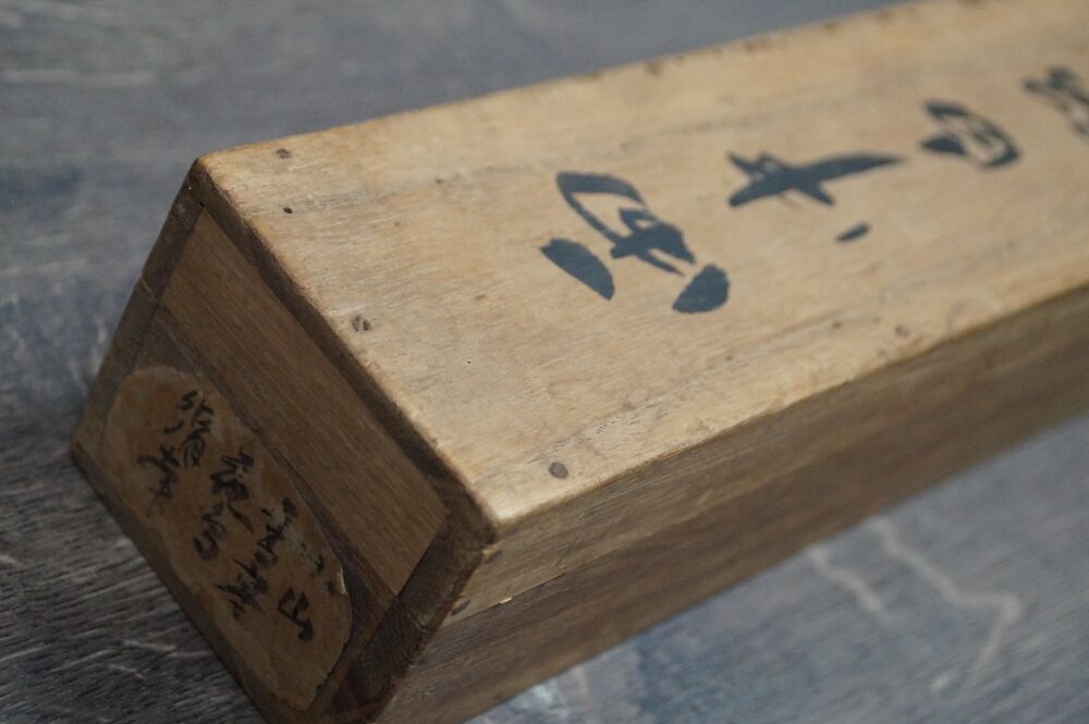 Deckel der Aufbewahrungsbox mit Kalligraphie-Beschriftung und Etikett des Kakemono