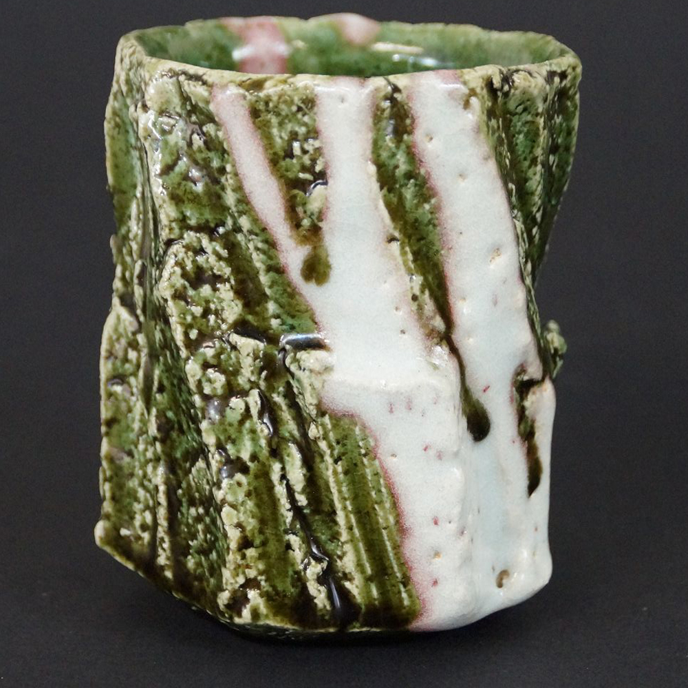 Yunomi Tee-Schale aus Oribe-Keramik von Kawachi Hidetoshi in der Gesamtansicht mit gruen-weiss-rosa gemusterter Glasur
