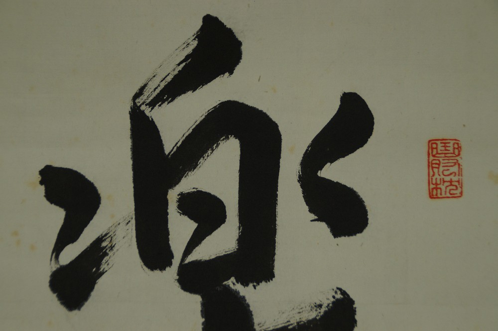 Nahaufnahme des oberen Teils des Schriftzeichens Raku mit rotem Siegel