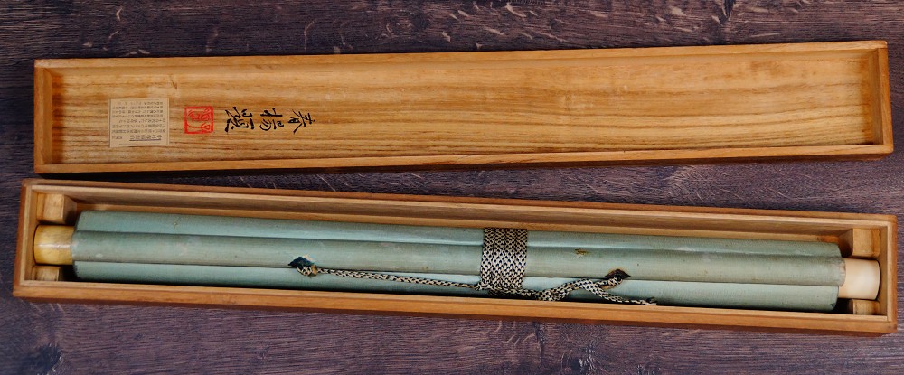 Zusammengerolltes Kakemono von Nakamura Shunyo in der offenen Aufbewahrungsbox mit Kordelverschnuerung