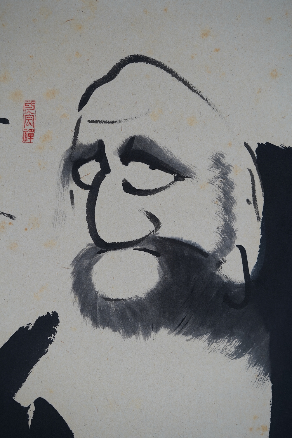 Weitere Nahaufnahme des Daruma-Gesichts mit ausdrucksstarkem Tuschepinselstrich
