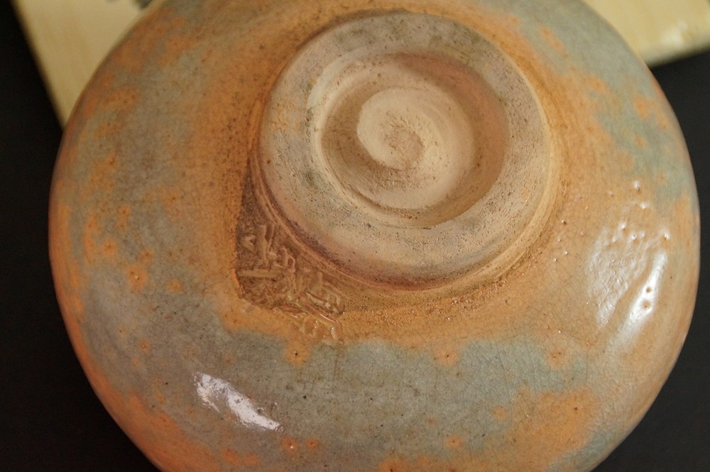 Primo piano del fondo con struttura a spirale e marchio dell'artista inciso