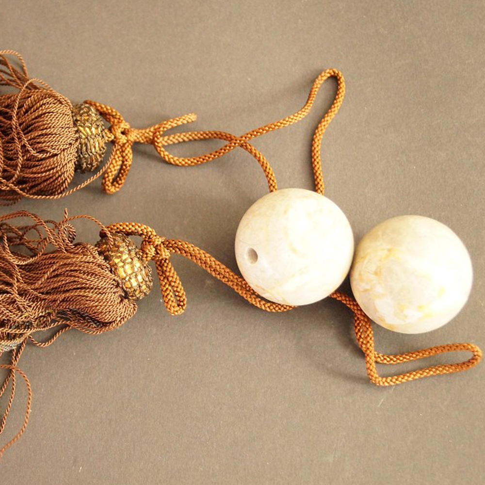 Zwei beige marmorierte Natursteinkugeln mit braunen Seidenquasten Set Nahaufnahme Vorschau
