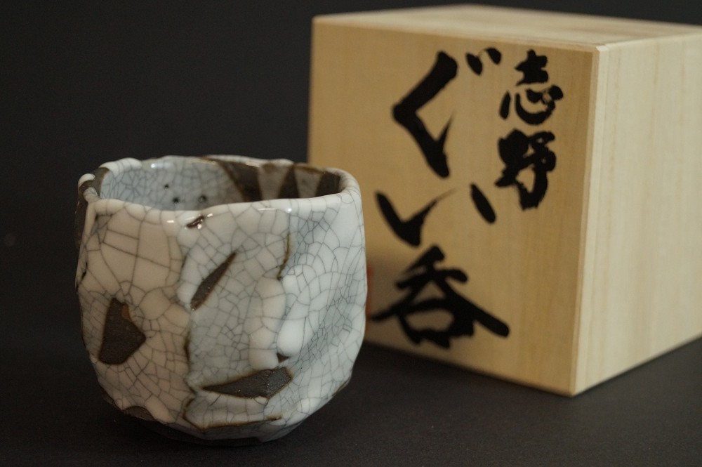 Coppa da sake accanto al cofanetto con iscrizione guinomi Shino vista frontale con cofanetto 2