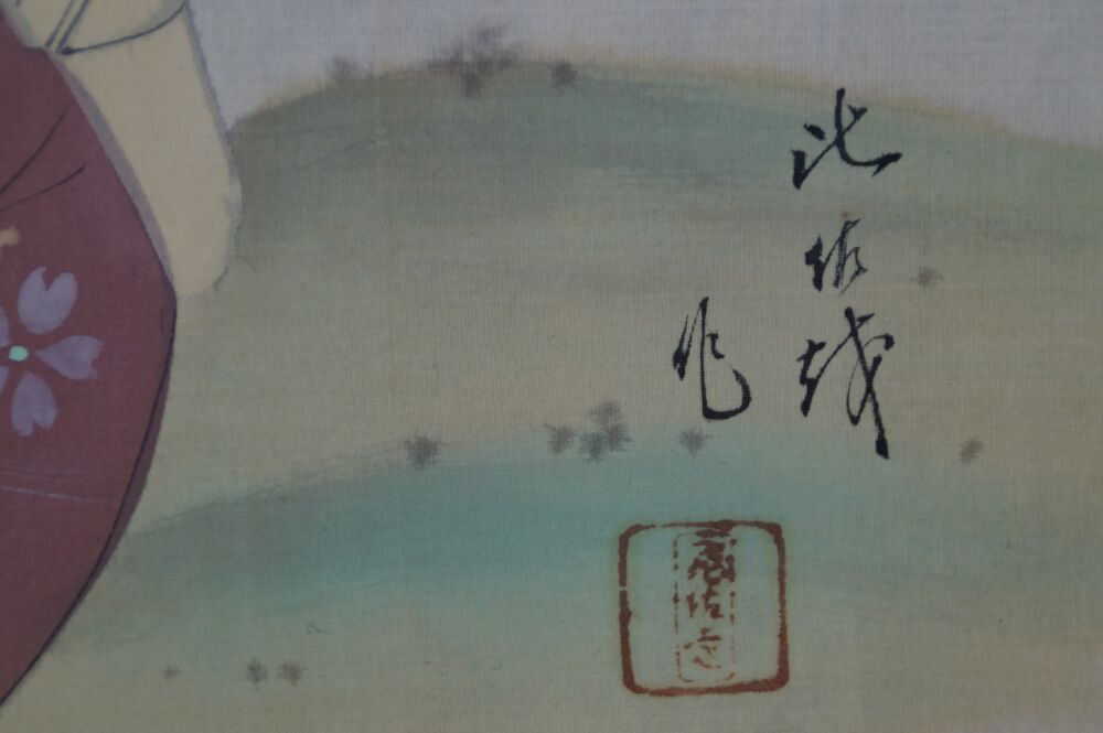 Vista dettagliata della firma dell'artista e del sigillo rosso su sfondo a inchiostro verde-blu nel kakemono dama in kimono presso lo stagno del giardino