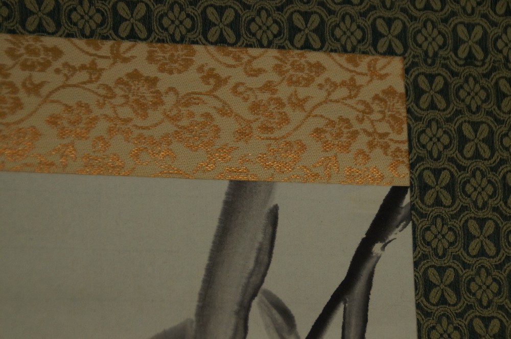 Close-up of the gold-patterned border on dark green silk