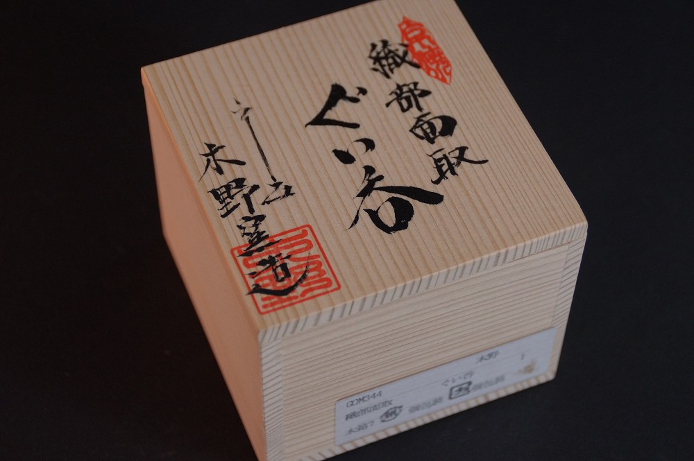 Nahaufnahme des Boxdeckels mit der Aufschrift Oribe Mentori Guinomi und rotem Kuenstlersiegel