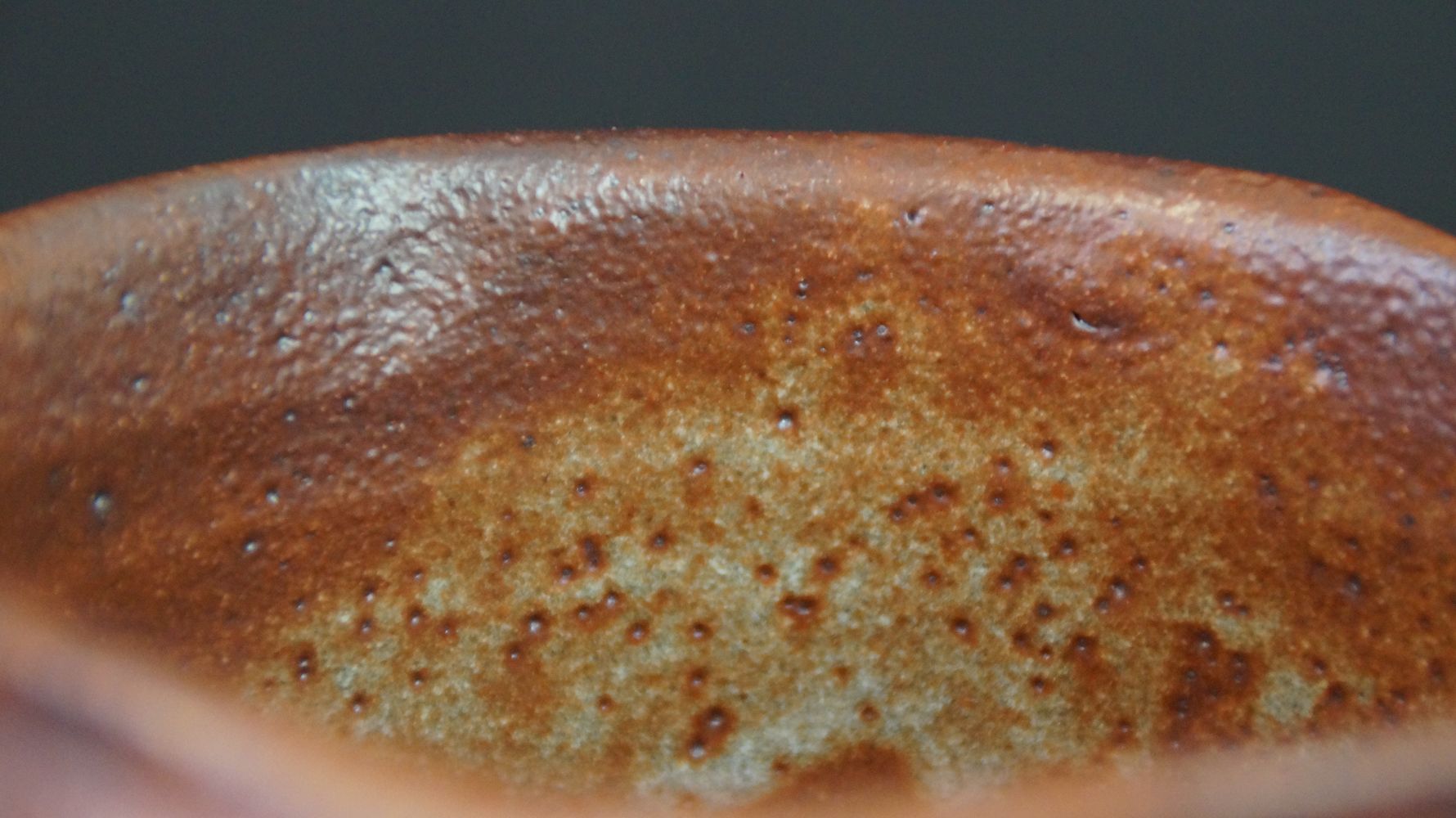 Nahaufnahme der rotbraun gesprenkelten Innenglasur der Chawan Teeschale aus Shino-Keramik
